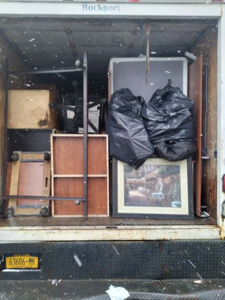 Disassembled furniture and boxes packed for moving in a truck.