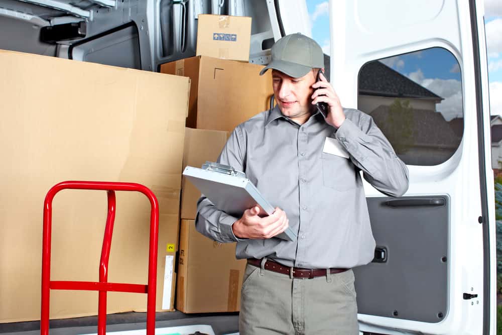 Professional moving company staff preparing packing supplies for a residential move.